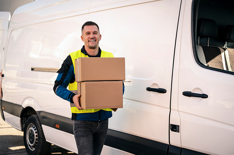 Delivery Man Carries Packages near Van
